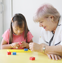 Adulta mayor y niña jugando con legos