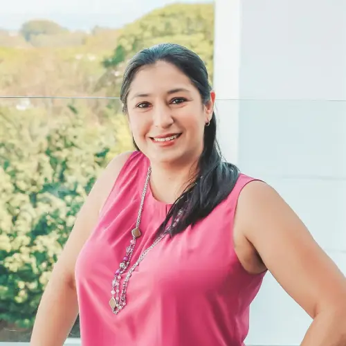 Mujer sonriendo con una blusa rosada